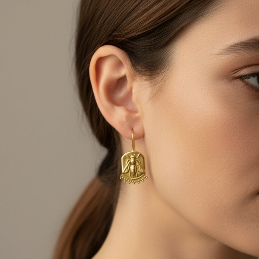 Close-up of Turkish artisan bee coin dangle earrings showing detailed 24K gold plating, handcrafted in Bodrum atelier
