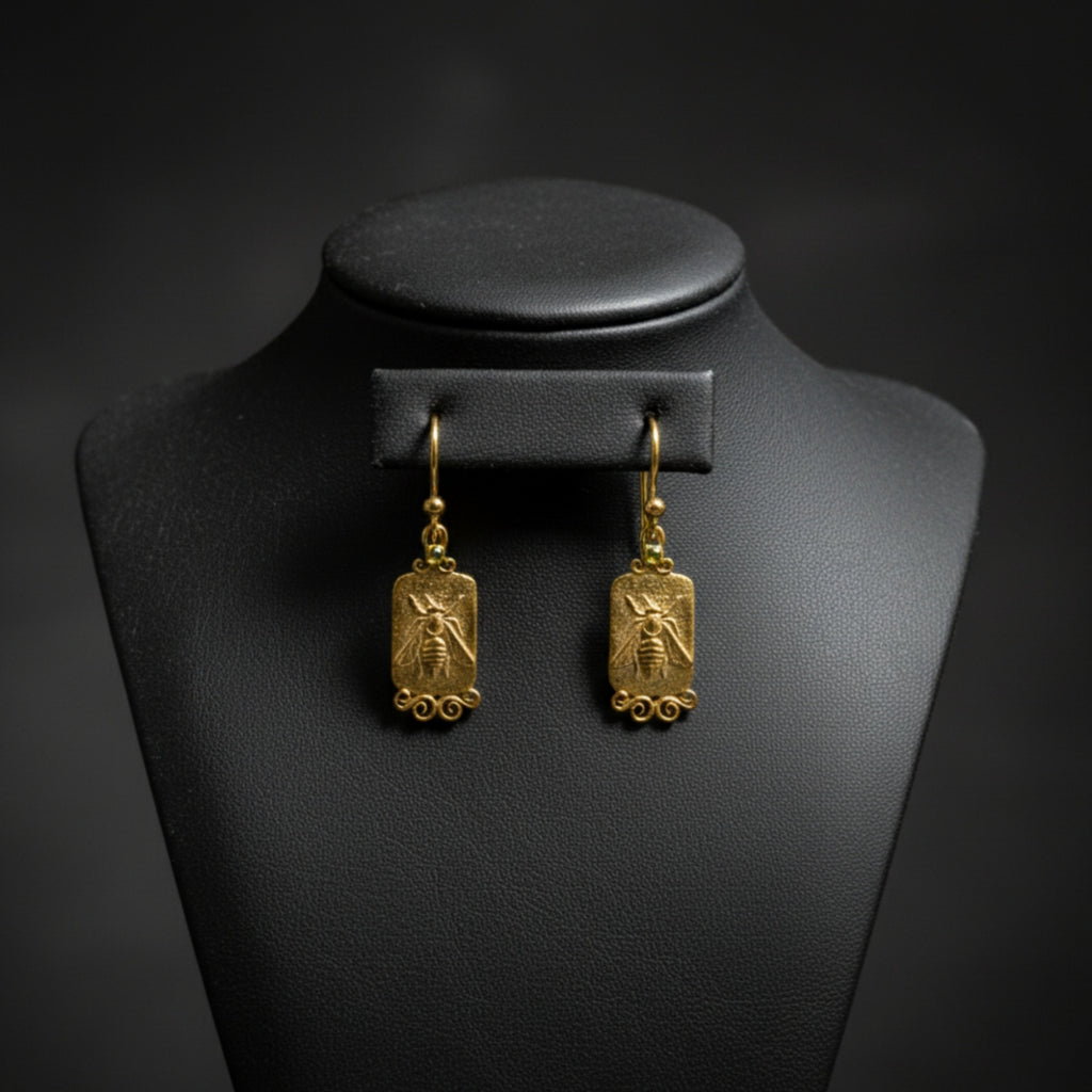 Artisan bee coin earring with green peridot detail showing hammered texture and gold plating on sterling silver, handmade Turkish jewelry

