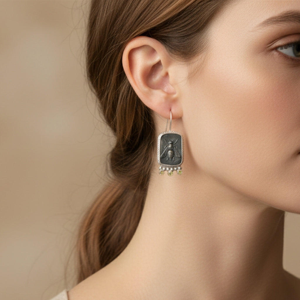 Close-up of Turkish artisan oxidized bee coin earrings withcanary topaz showing detailed blackened finish, handcrafted in Bodrum atelier
