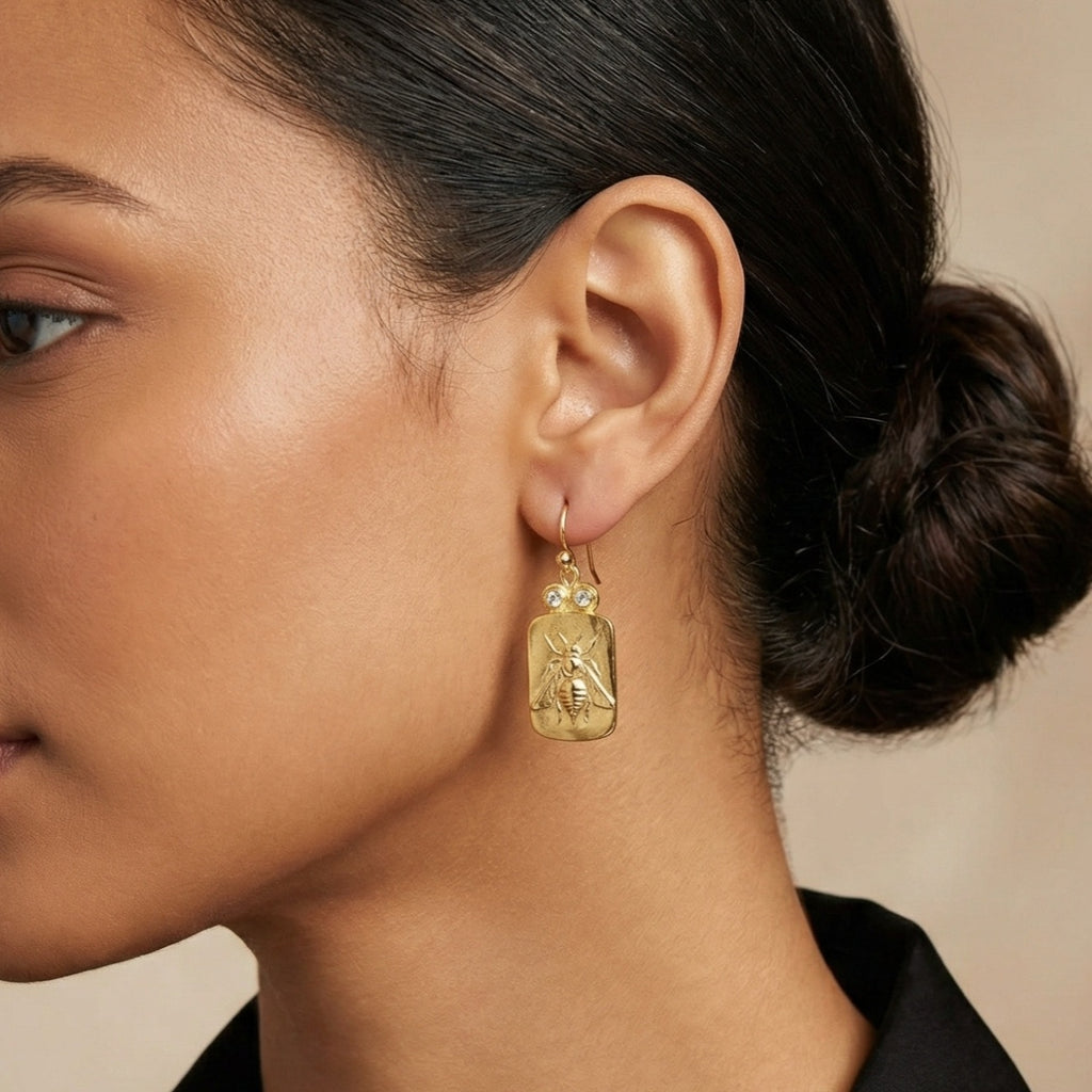 Close-up of Turkish artisan bee coin dangle earrings showing detailed 24K gold plating, handcrafted in Bodrum atelier
