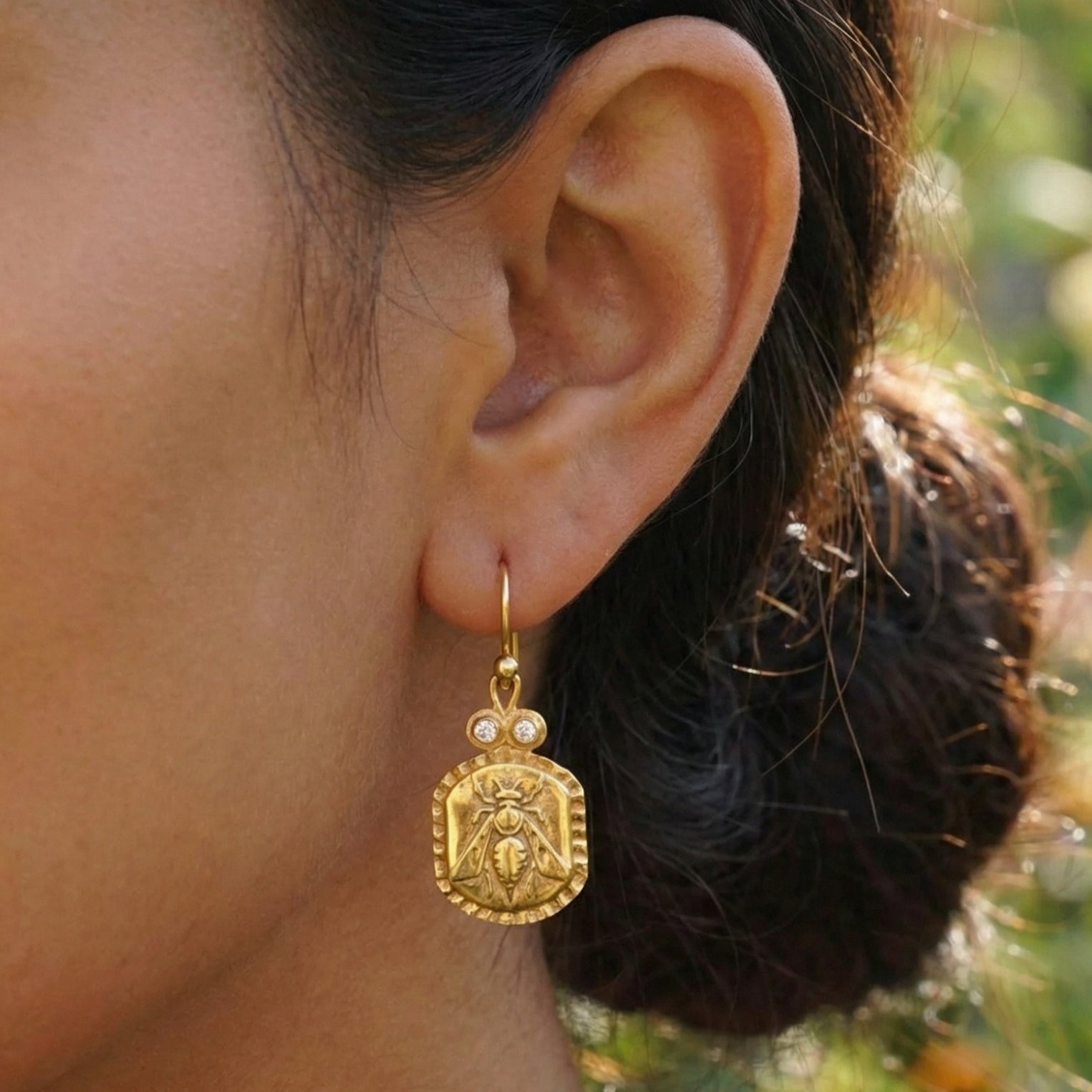 Close-up of Turkish artisan bee coin earrings with white topaz showing detailed 24K gold plating, handcrafted in Bodrum atelier
