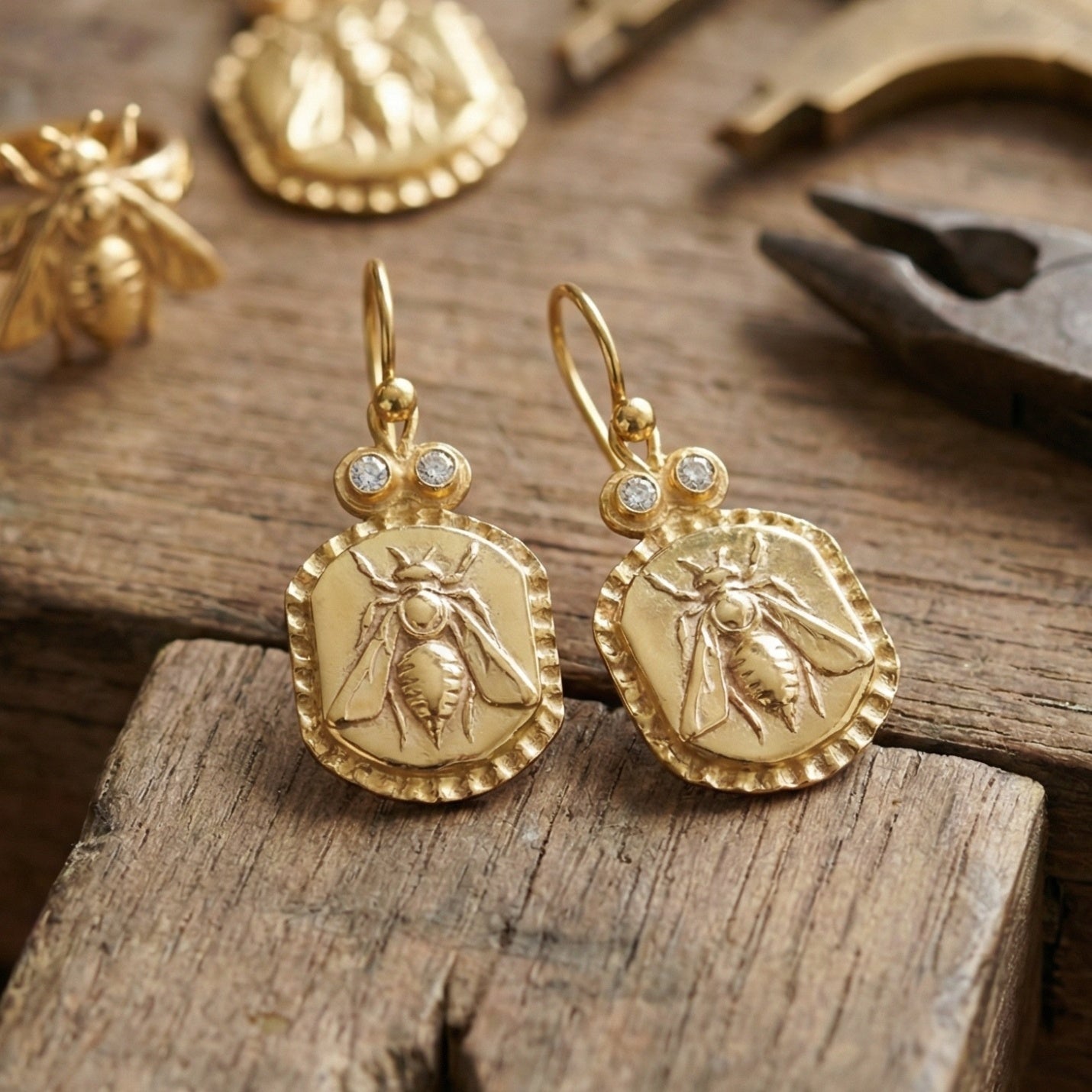 Artisan bee coin earring with white topaz detail showing hammered texture and gold plating on sterling silver, handmade Turkish jewelry
