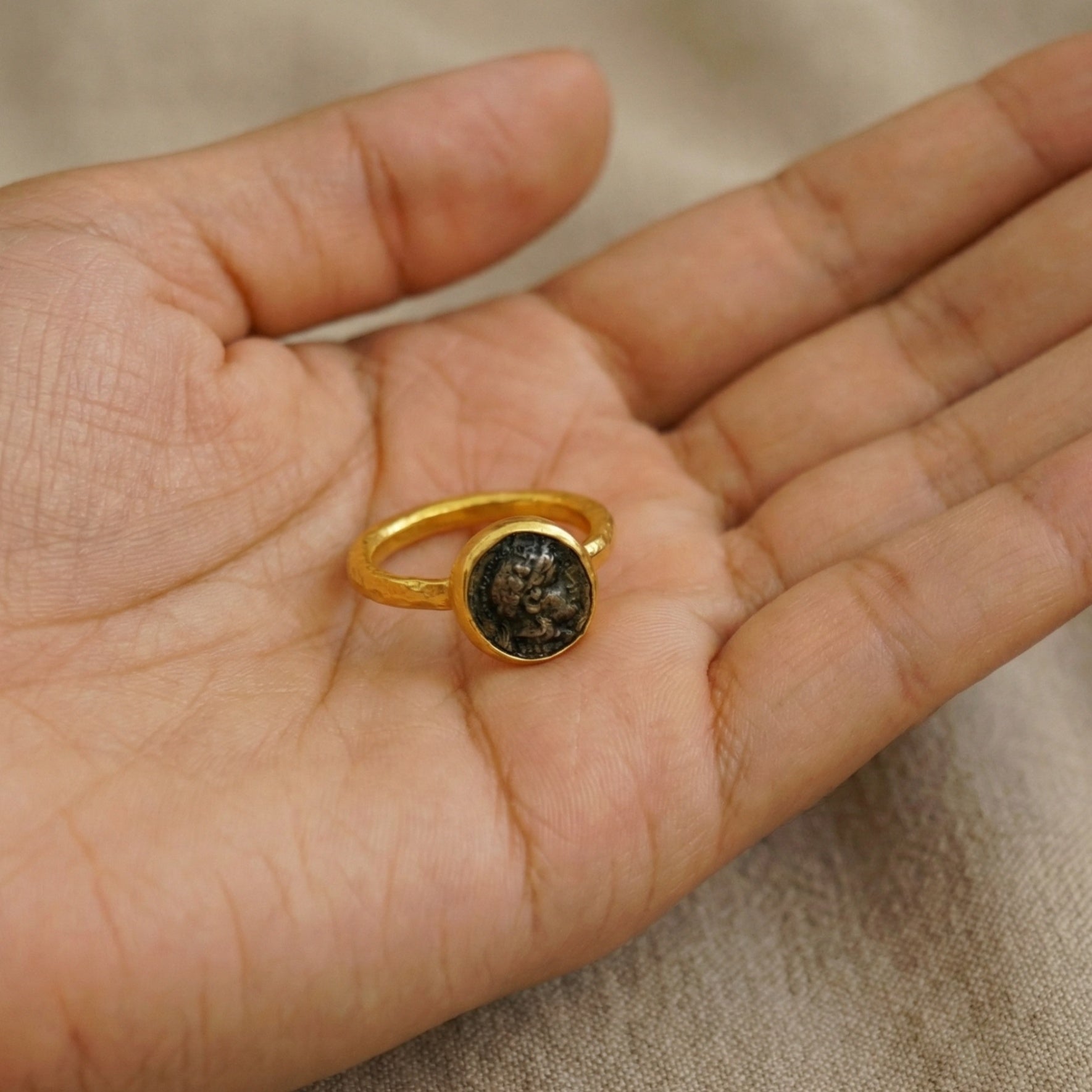 Designer Alexander coin ring detail, hammered texture, leadership symbol