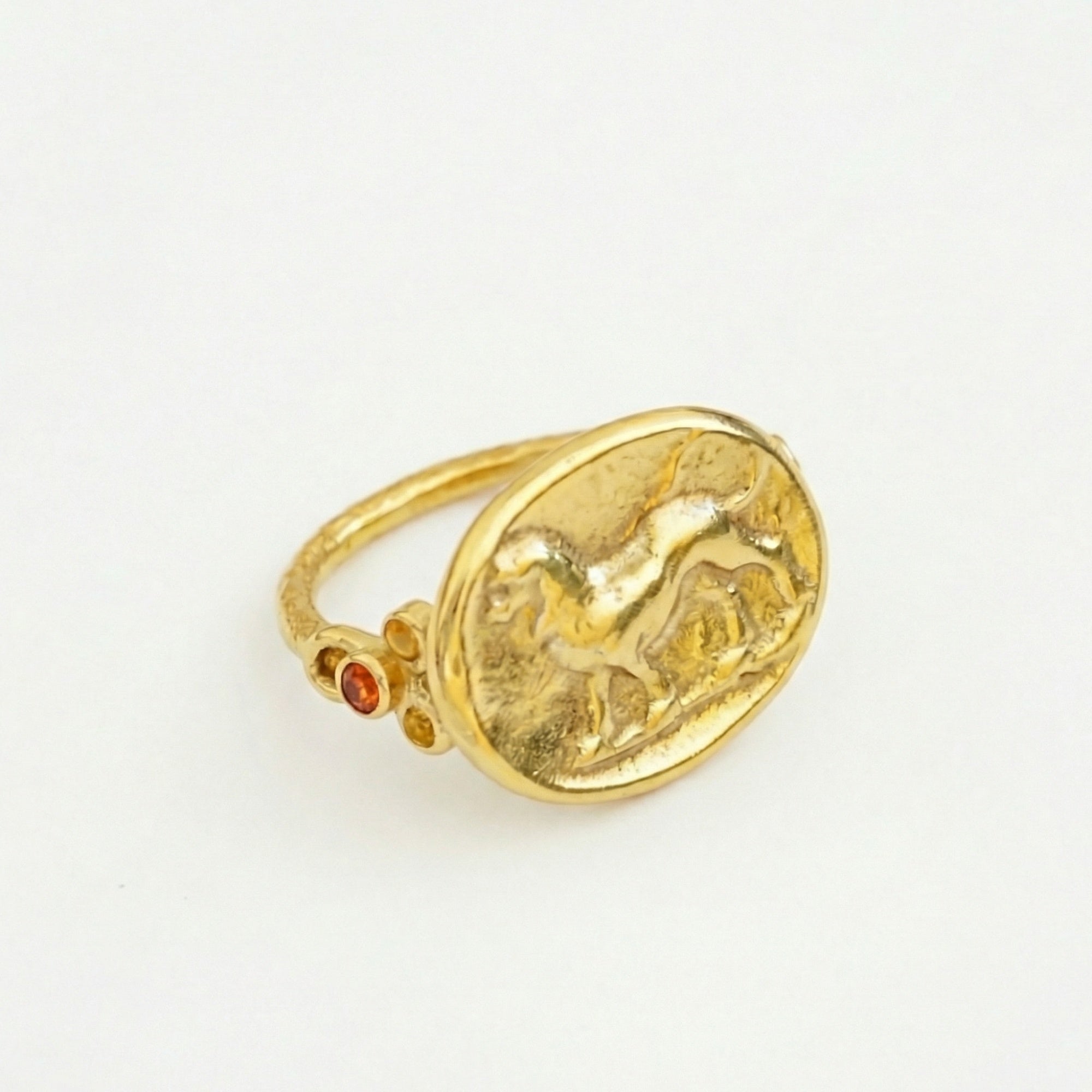 Gold-plated lion coin ring on hand with orange topaz, timeless Turkish jewelry by designer Sultan