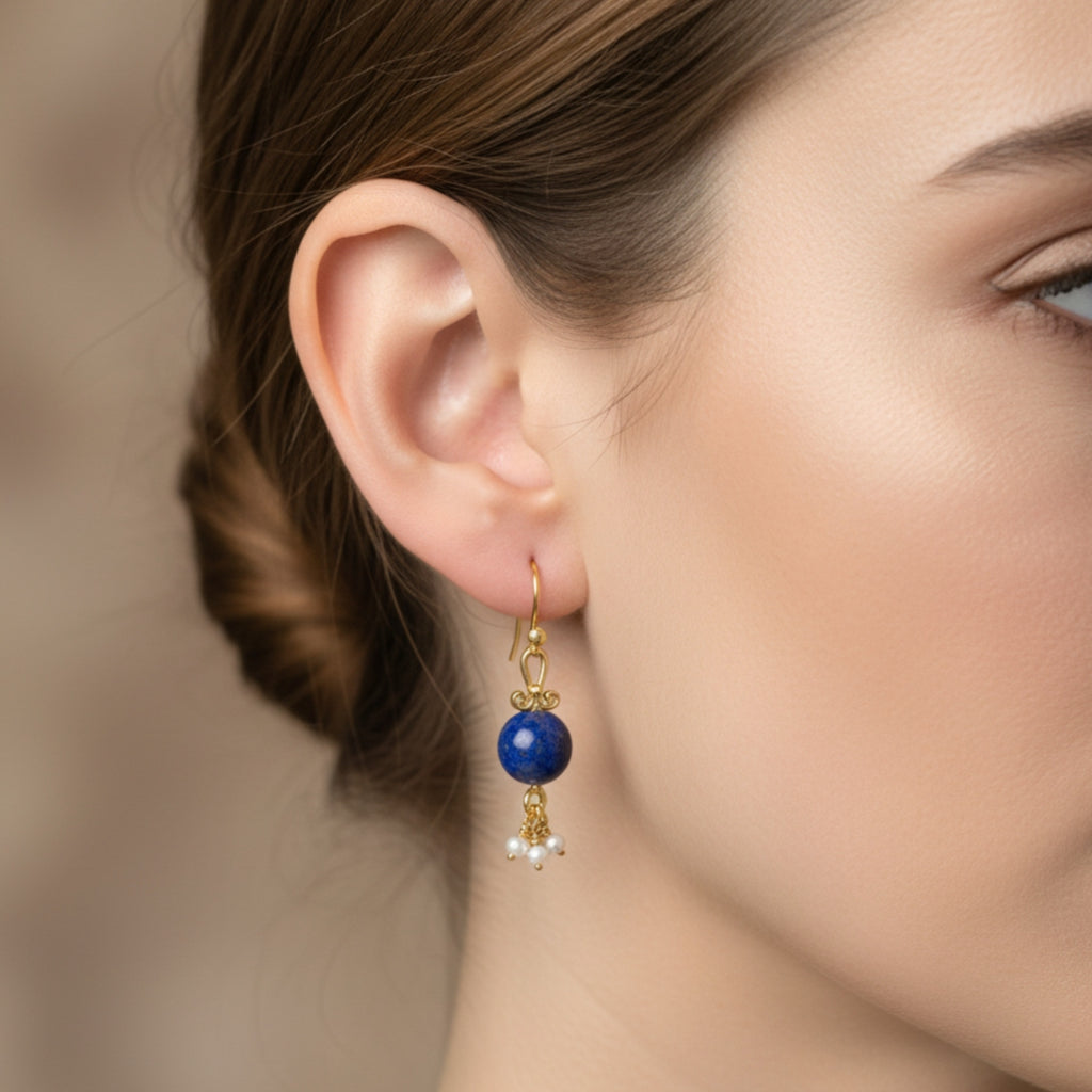 Close-up of natural lapis lazuli gemstone and freshwater pearl on handmade Turkish earrings with antique gold finish